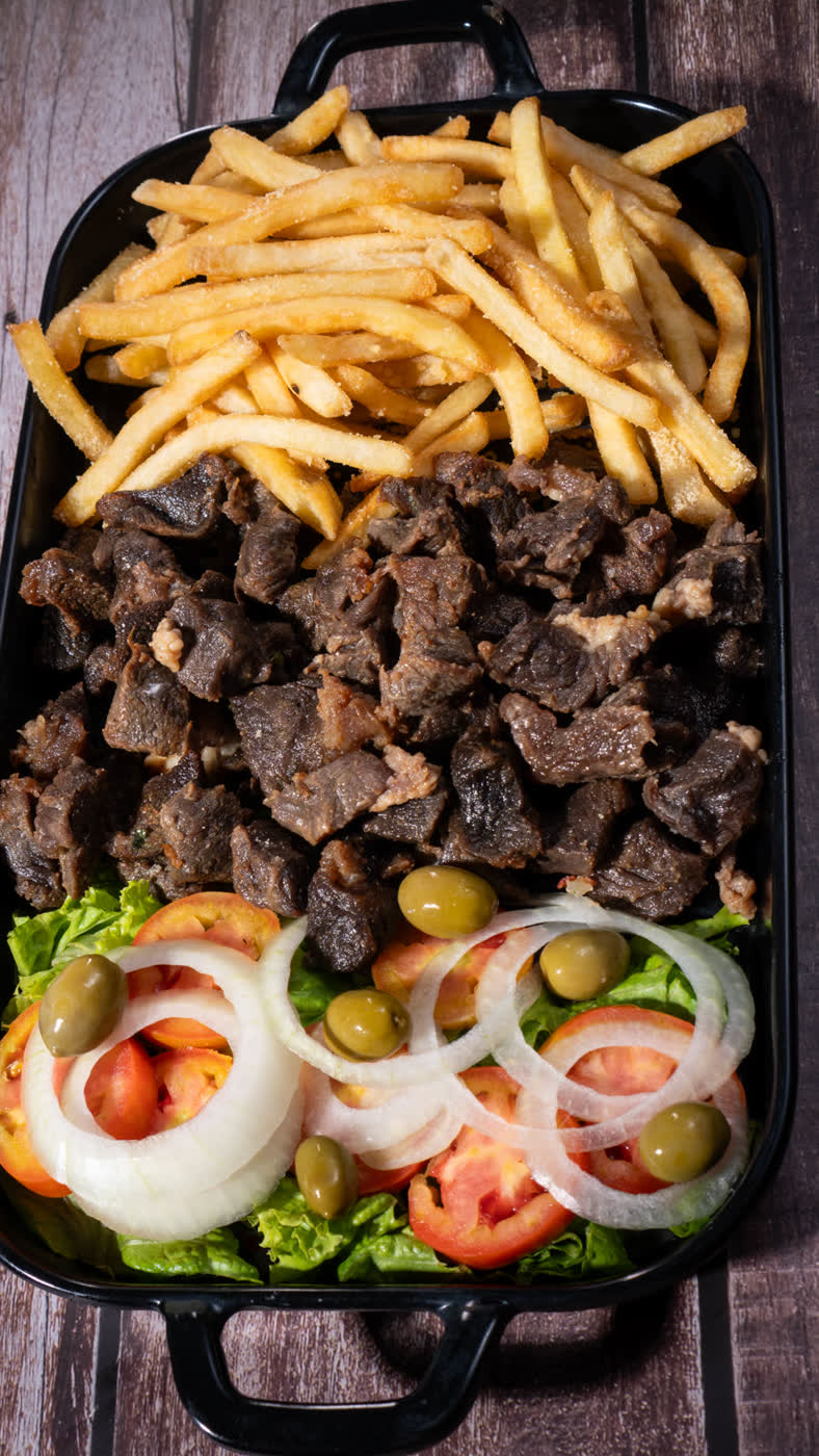 Carne grelhada com fritas em travessa rústica