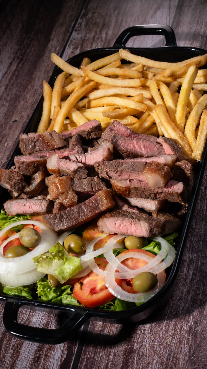 Contrafilé fatiado com salada na travessa